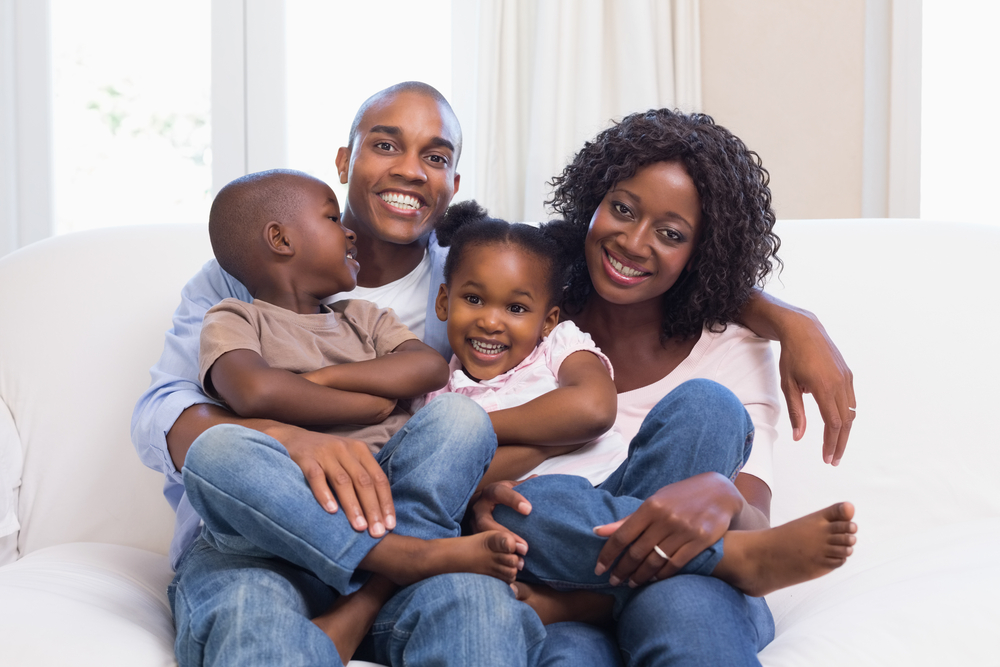 Happy family posing on the couch together at home in the living room