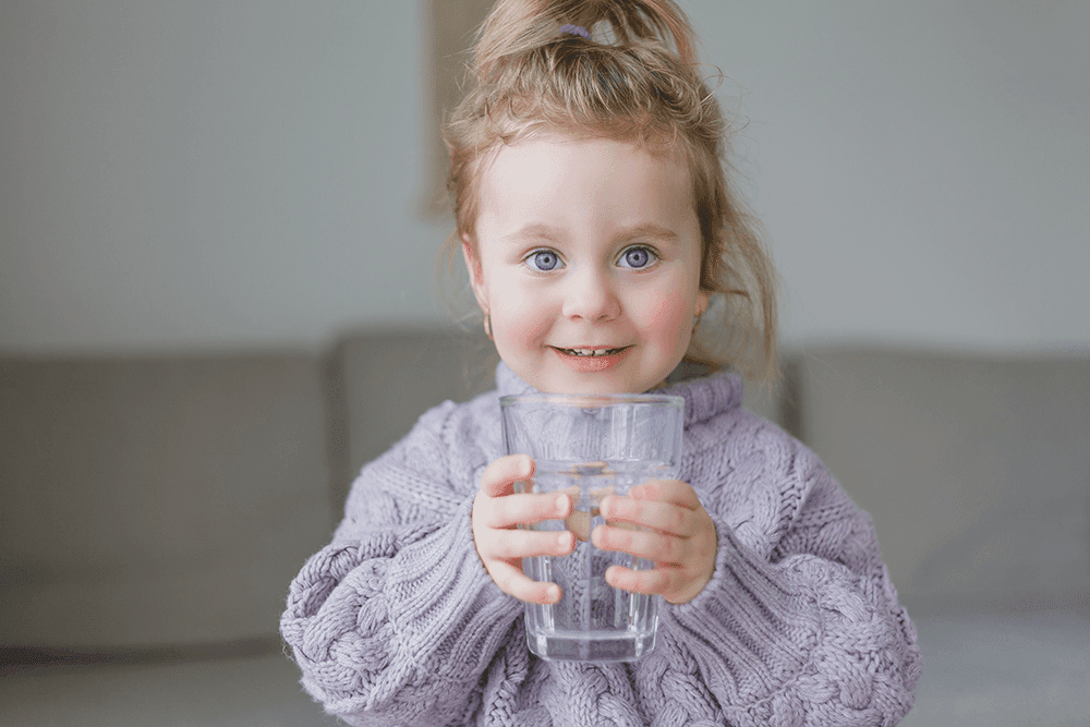 a-little-girl-holds-a-glass-of-water-drinks-2021-10-01-17-39-50-utc