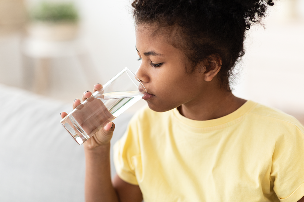 black-kid-girl-drinking-water-sitting-on-sofa-at-h-2021-08-29-03-31-10-utc